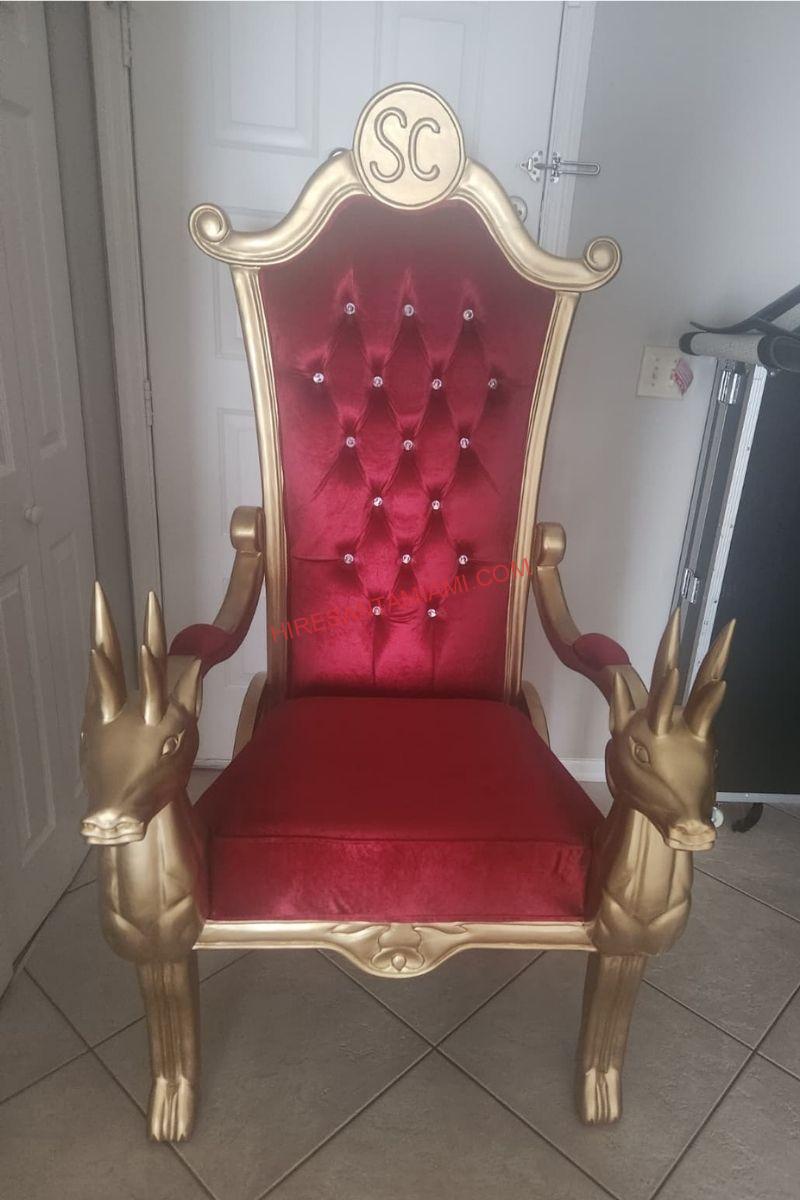 Tufted red Santa throne with gold reindeer armrests and a monogrammed crest